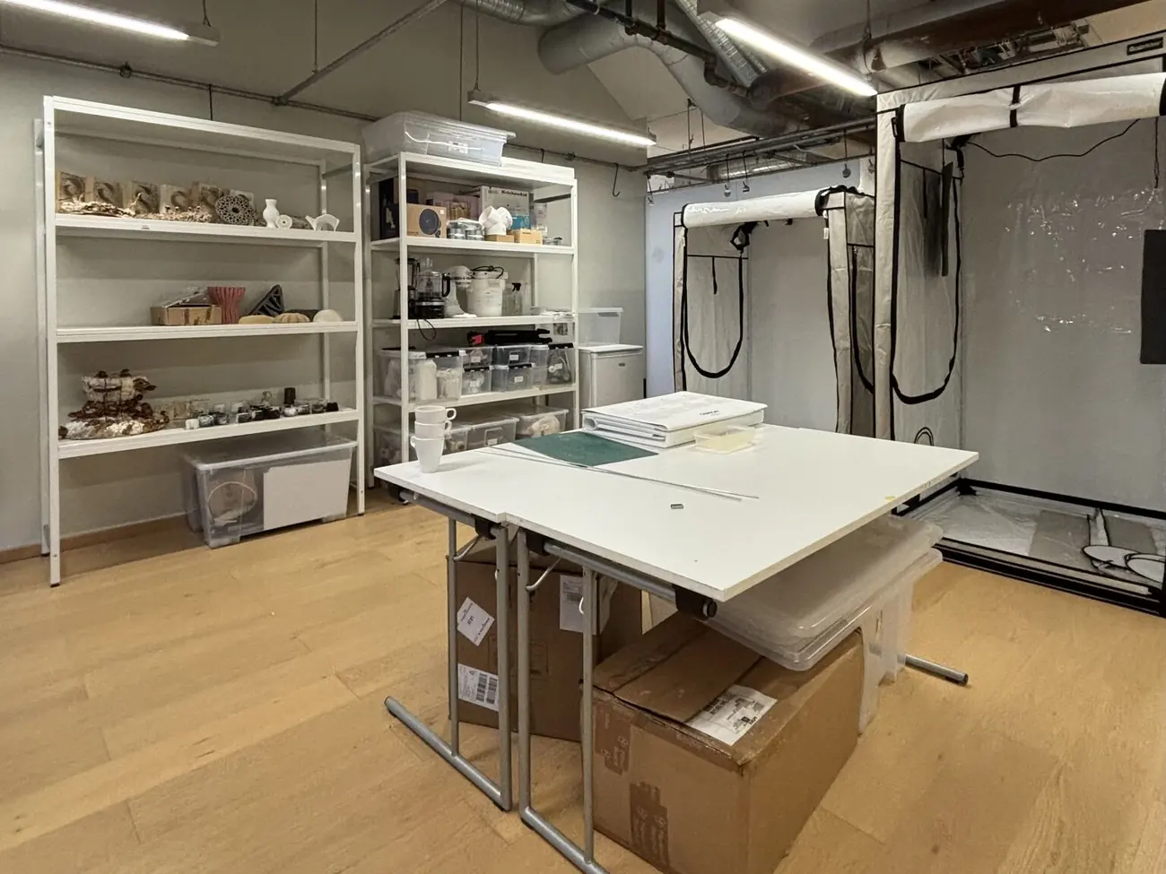 The Material Practices Lab: grow tents, a work table and shelves of printed samples