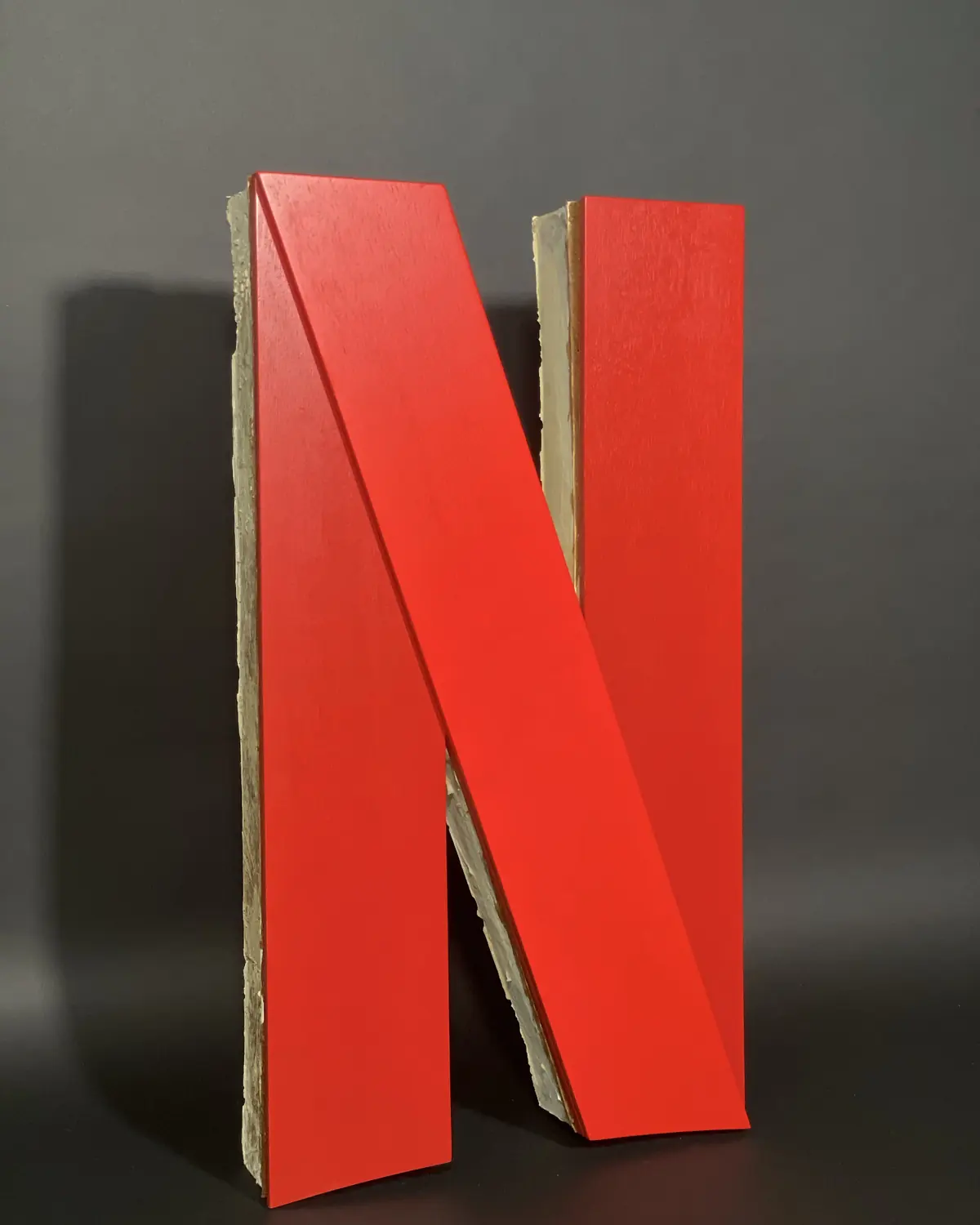 The finished letter N, painted red, its grown edges visible