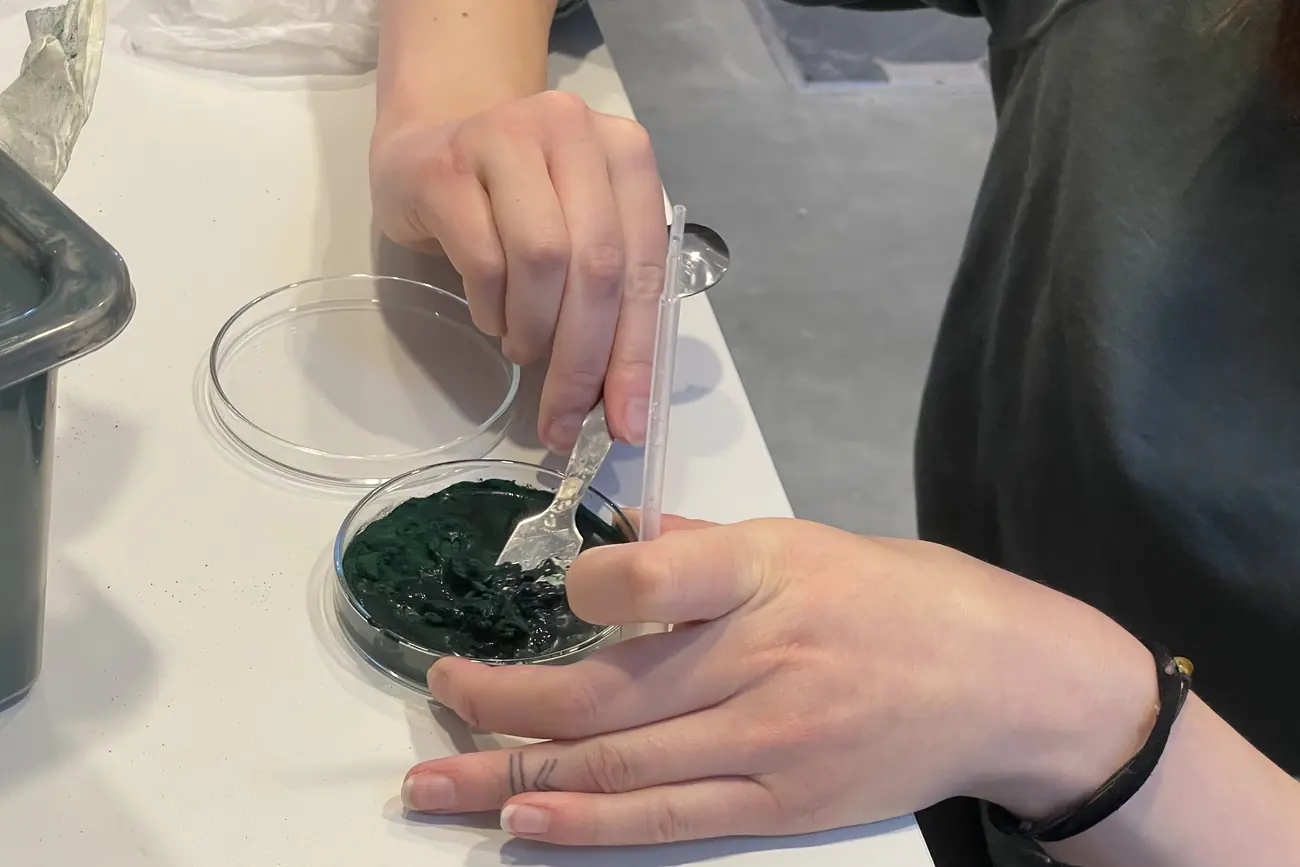 A student's hands inoculating a petri dish