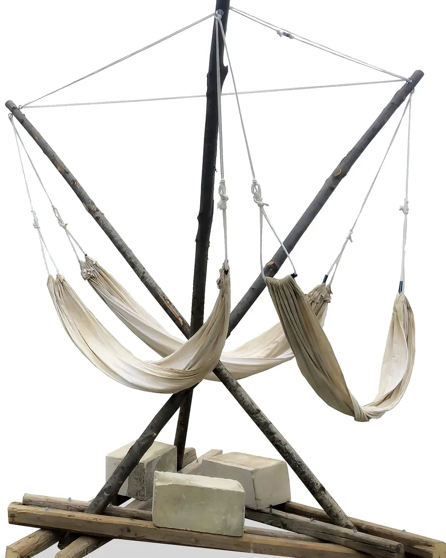 Three crossed chestnut poles on stone blocks, carrying three white hammocks