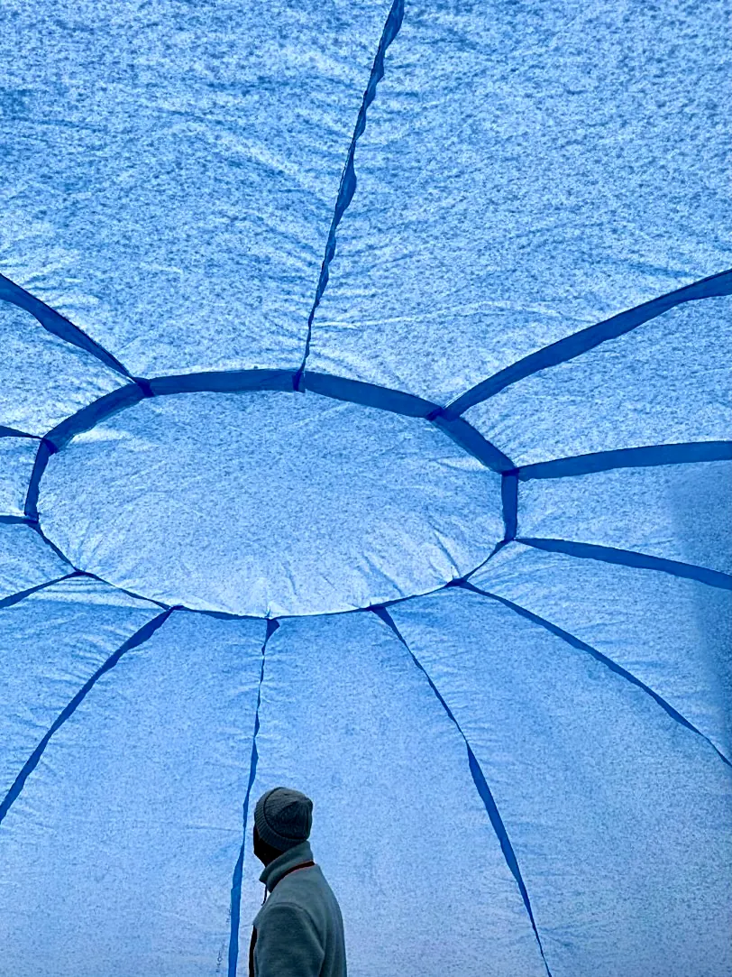 Snow on the dome's blue skin, its seams meeting at the top